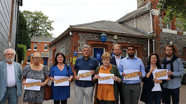 Liberal Democrat activists with sign that say Reopen Romsey Police Station front desk