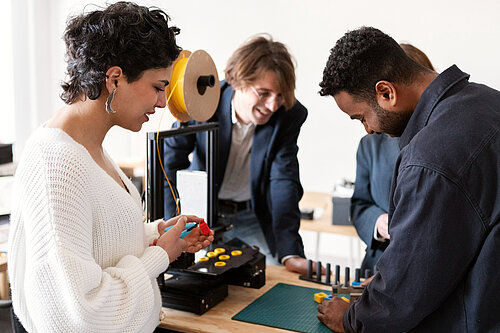 Four people in a practical training setting, solving a problem